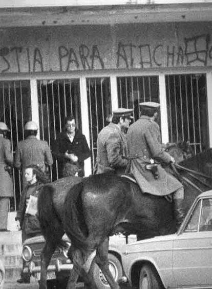 Dos policías montados a caballo frente a una fachada con pintadas referentes a la matanza de los abogados laboristas en la calle Atocha. Se hicieron durante el asalto ultraderechista que tuvo lugar en la facultad de Derecho de la Universidad Complutense de Madrid el 26 de Enero de 1979.