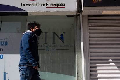 Un hombre pasa afuera de una farmacia homeopática. 