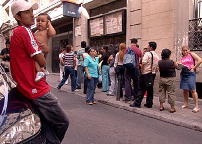 Varios extranjeros, ante una oficina de regularización de inmigrantes en Madrid.