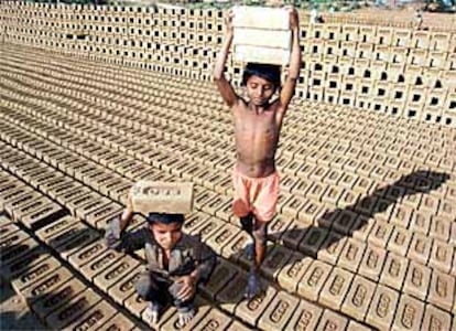 Dos niños transportan ladrillos en una fábrica de Chandigam (India).