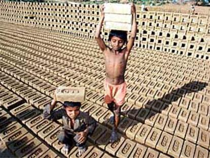 Dos niños transportan ladrillos en una fábrica de Chandigam (India).