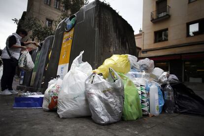 Contenedores de reciclaje completamente llenos en la calle del Pez.