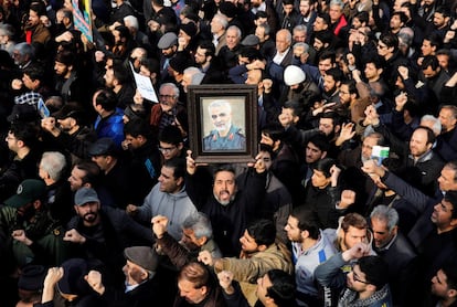 Un manifestante alza un retrato del difunto comandante de la Fuerza Quds de los Guardianes de la Revolución de Irán, Qasem Soleimaní, durante una protesta multitudinaria contra EEUU, el día 3 de enero en Teherán (Irán).