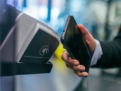 Un usuario paga una compra con tecnología NFC a través de su móvil.