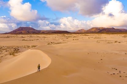 Un caminante entre dunas por el parque natural de Corralejo, en la isla canaria de Fuerteventura.