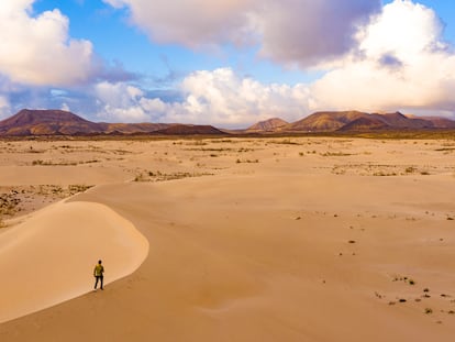 Un caminante entre dunas por el parque natural de Corralejo, en la isla canaria de Fuerteventura.