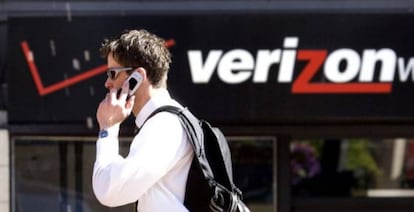 Un hombre habla por teléfono ante una tienda de Verizon.