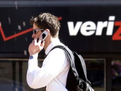 Un hombre habla por teléfono ante una tienda de Verizon.
