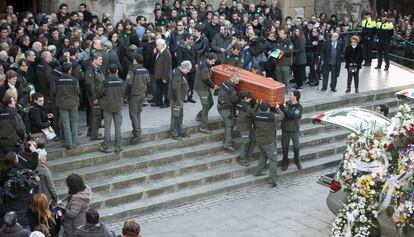 Companys dels agents traslladen el fèretre d'una de les víctimes en el seu funeral.