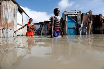 Dos niños somalíes caminanpor las calle inundadas después de fuertes lluvias en Mogadiscio (Somalia).

