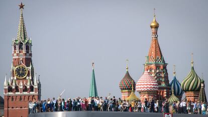 Un grupo de personas camina por un puente en el parque de Zaryadye, cerca de la baslica de San Basilio y la torre Spasskaya, en Mosc (Rusia).