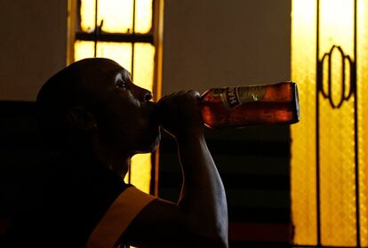 Un adorador de la Iglesia de Gabola bebe cerveza durante un servicio en un bar en Orange Farm, al sur de Johannesburgo, el domingo 15 de abril de 2018.