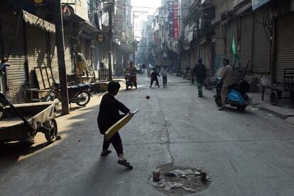 Niños paquistaníes juegan al cricket en una calle de  Lahore (Pakistán).