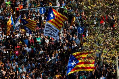 Un grupo de personas reunidas frente al Parlament en Barcelona ondean pancartas y esteladas. 