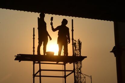 Trabajadores pintan un puente en Amritsar (India). 