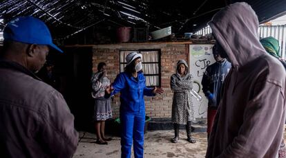 Una mujer explica las medidas de contención del coronavirus a un grupo de personas en Johanesburgo (Sudáfrica).