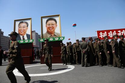 Soldados de Corea del Norte pasan junto a los retratos de los exlíderes Kim Il-sung y Kim Jong-il tras una ceremonia de inauguración de un nuevo proyecto de desarrollo residencial en Pionyang (Corea del Norte) hoy, 13 de abril de 2017. EFE/How Hwee Young