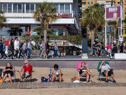 Varios turistas en la playa y en el paseo de la playa del Levante de Benidorm, este diciembre.