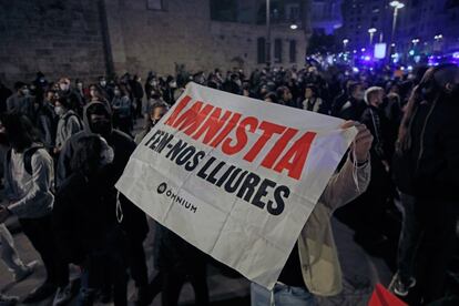 Una persona lleva una pancarta durante la concentración convocada en Valencia en protesta por la detención e ingreso en prisión del rapero Pablo Hasél.