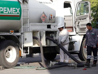 Trabajadores de Pemex surten combustible, este lunes en una gasolinera de Guadalajara.
