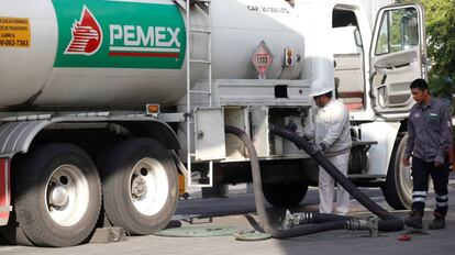 Trabajadores de Pemex surten combustible, este lunes en una gasolinera de Guadalajara.