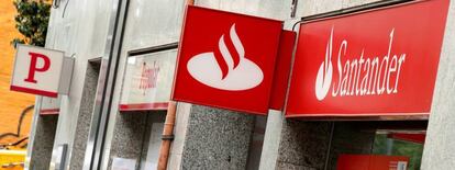 Una mujer camina junto a unas oficinas del Banco Santander y Popular.