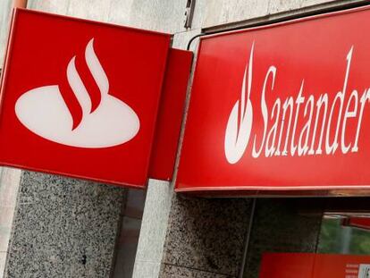 Una mujer camina junto a unas oficinas del Banco Santander y Popular.