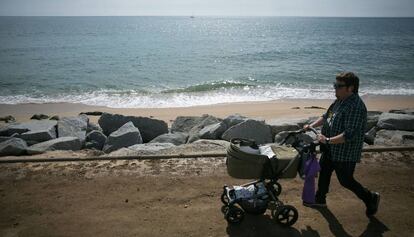 Un pare passeja el seu fill per la platja.