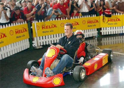 El piloto alemn Michael Schumacher ha llegado a la rueda de prensa en Melbourne en kart y acompa?ado por un ni?o de siete a?os.