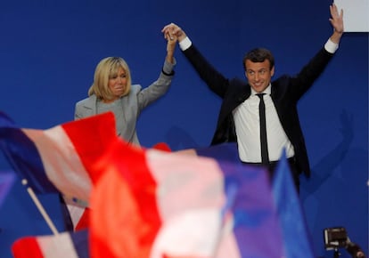 Emmanuel Macron, nuevo presidente francés, y su mujer Brigitte Trogneux, suben al escenario para celebrar los resultados de la primera vuelta de las elecciones francesas en el hall del Parque de Exposiciones de París, el 23 de abril de 2017.