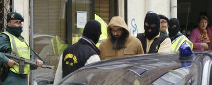 Agentes de la Guardia Civil trasladan a uno de los integrantes de la célula islamista desarticulada en Burgos.