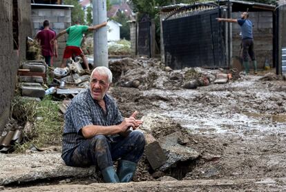 Un anciano descansa mientras sus vecinos limpian sus casas inundadas en el pueblo Stajkovci de Skopie. Al menos 20 personas han fallecido por culpa del temporal.