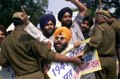 Miembros de la policía contienen a un grupo de hindúes que protestan en contra de los musulmanes en Nueva Delhi