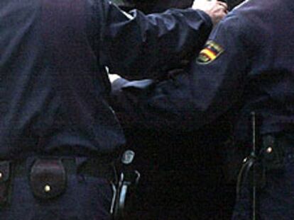 Alfonso Martínez Lizarduikoa, detenido ayer, es introducido en un coche policial tras registrar su domicilio.