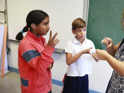 Maite, responsable de lenguaje de signos, habla con dos alumnos sordos