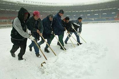 Operarios del club austriaco trabajan para quitar la nieve del estadio Ernst Happel.