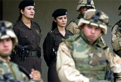 Dos policías kurdas, junto a soldados estadounidenses, vigilan la entrada del ayuntamiento de Kirkuk.