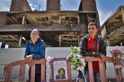 Ada y Atmán, vecinos del bloque de viviendas okupado que fue incendiado, posan el 20 de mayo de 2019 junto a una ofrenda a Rossana Venturini, una mujer italiana de 59 años que trabajaba para un grupo hotelero. Esta barcelonesa de 40 años, que llegó a Ibiza en 2004, pasó de un estudio que pagaba con un sueldo de cajera a ocupar una obra abandonada. El día del incendio se refugió en la azotea e Internet se ha llenado en los últimos días de imágenes de su rescate en helicóptero. Ahora gana 1.000 euros al mes en los servicios municipales de limpieza, pero en invierno, explica, solo trabaja fines de semana y cobra 300 euros.