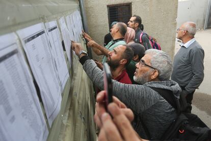 Un grupo de personas comprobaban que sus nombres estuvieran en las listas para poder salir de la franja de Gaza por el paso fronterizo de Rafah a Egipto, este lunes.