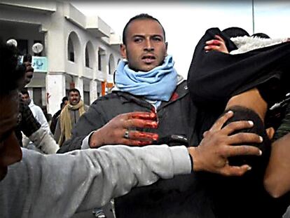Varios manifestantes trasladan a hombros a un hombre herido durante enfrentamientos con la policía.