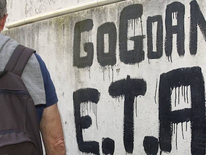 Un hombre camina junto a una pintada que reza &quot;ETA, Pa&iacute;s Vasco y Libertad&quot;.