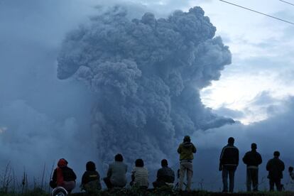 Unos hombres contemplan la erupción del Monte Sinabung en Tiga Kicat, Sumatra del Norte (Indonesia). 