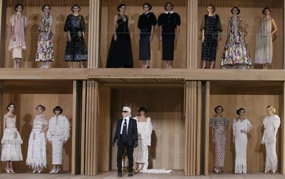 El diseñador Kar Lagerfeld (con gafas de sol), frente a algunos de sus diseños de alta costura para Chanel.