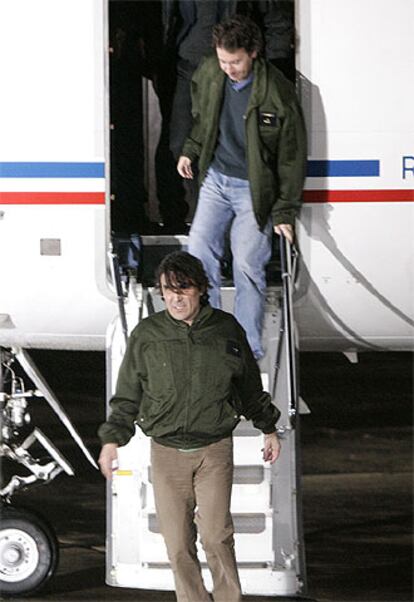 Georges Malbrunot, delante, y Christian Chesnot, descienden del avión que les ha devuelto a Francia.