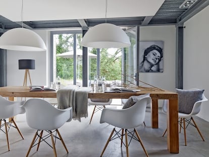 El salón, que conserva
las vigas de forjado
de la edificación original, comunica con el jardín. Todas las lámparas son de Ikea; las sillas blancas modelo Daw de Charles & Ray Eames, de Vitra, y los cojines y las mantas de la mesa de madera son de la firma Kardelen The Lovely Linen Maker.