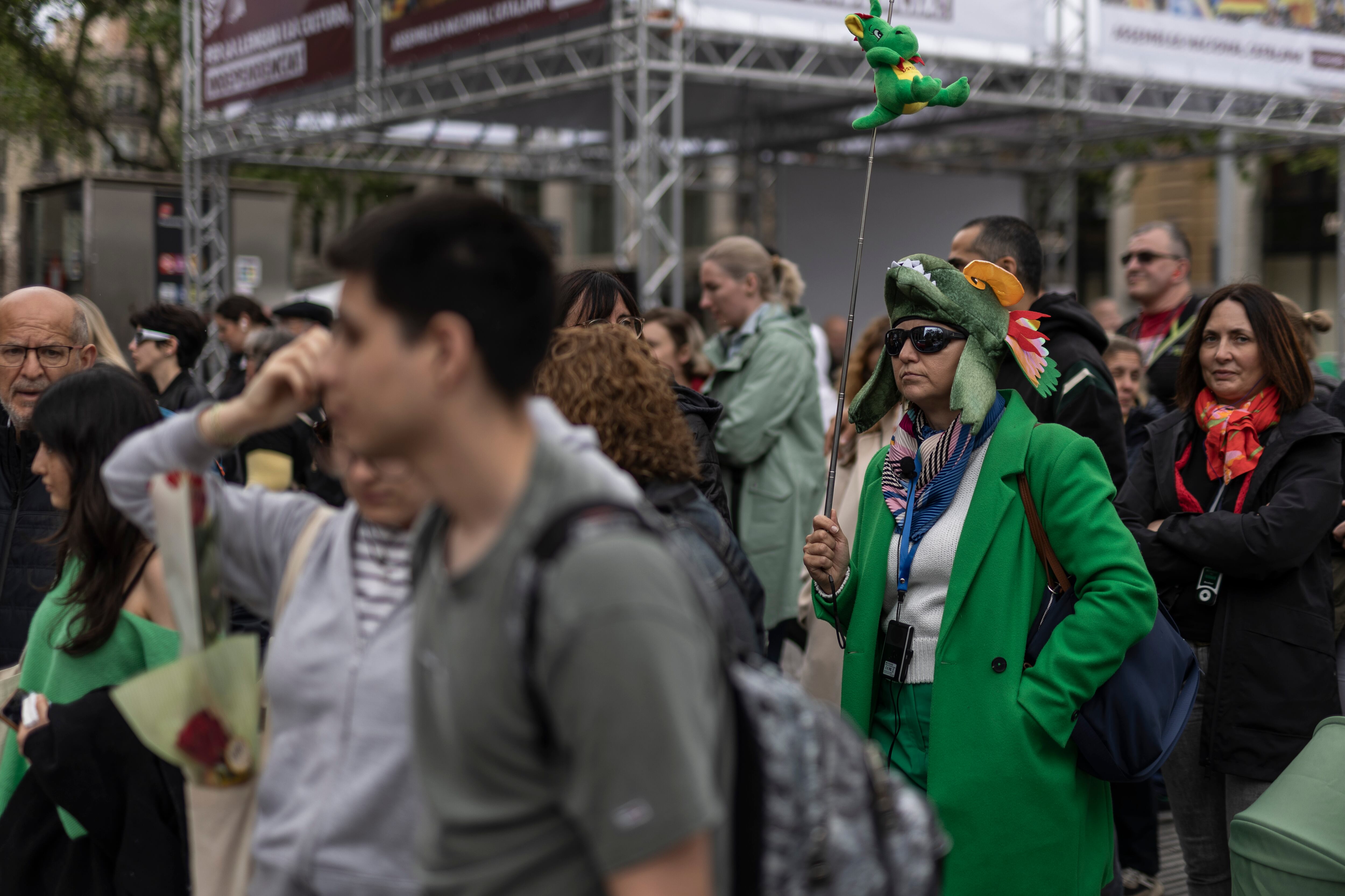 Una guía turística disfrazada de dragón dirige a un grupo de personas durante la Diada de Sant Jordi, este martes en el Paseo de Gracia.