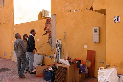 Un grupo de vecinos observa los daños en las paredes de sus casas de Vícar.