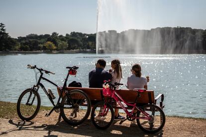 Una familia descansa en un banco en el Lago de Casa de Campo.