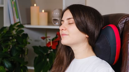 Una chica en una silla con un masajeador cervical.