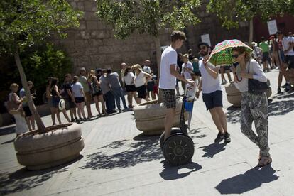 Una turista en Sevilla se protege del sol con un paraguas.